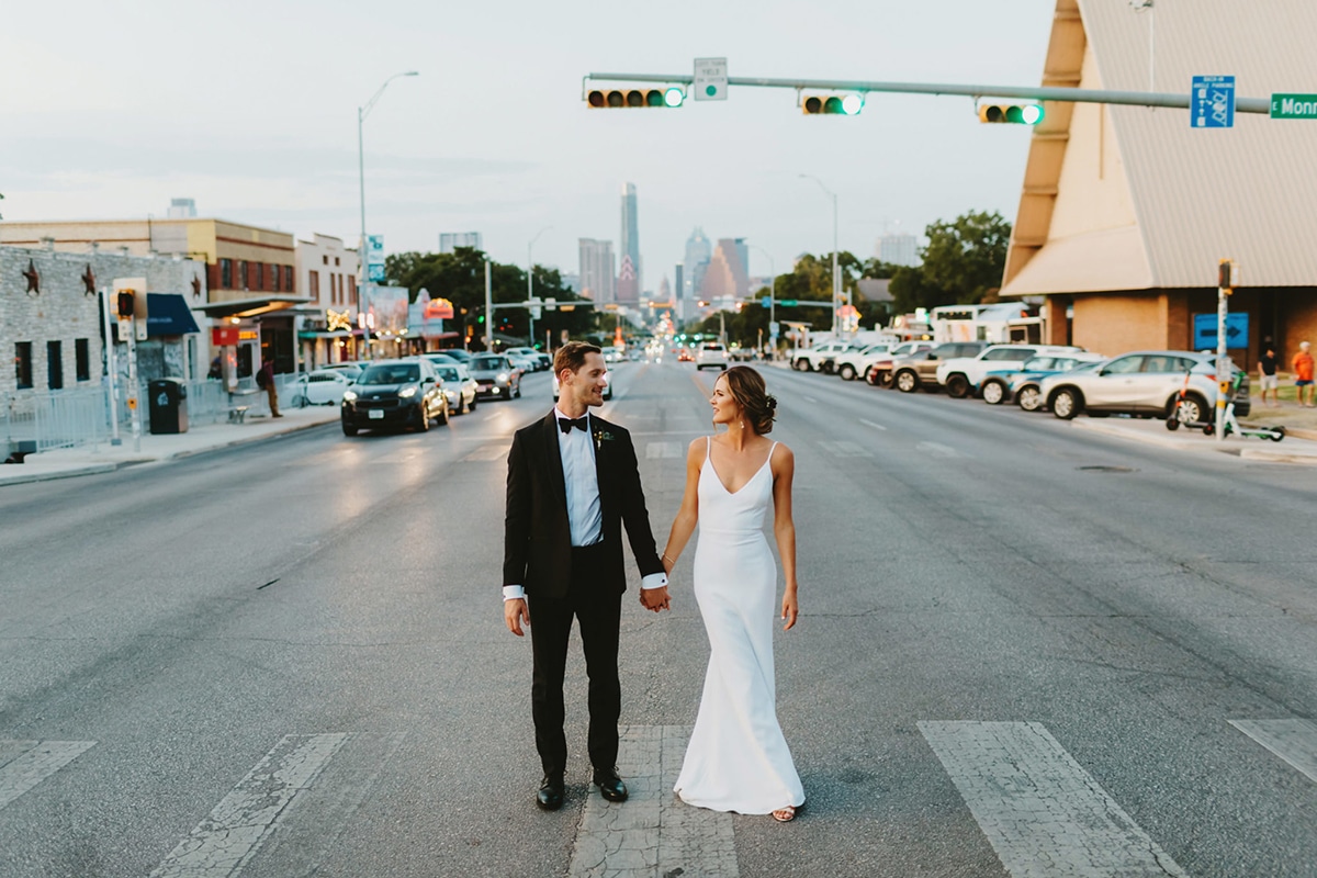 a man and woman holding hands on a street